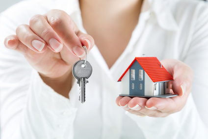 Wohnungsschlüssel mit Haus und Frau