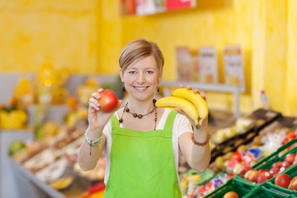 Verkäuferin mit Bananen und Apfel