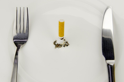 Zigarette mit Frühstücksteller, Gabel und Messer