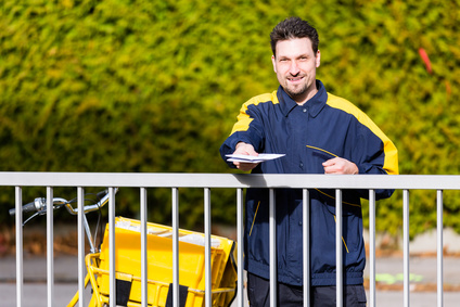 Postbote übergibt Briefumschlag