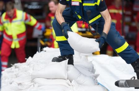 Helfer transportiert Sandsäcke
